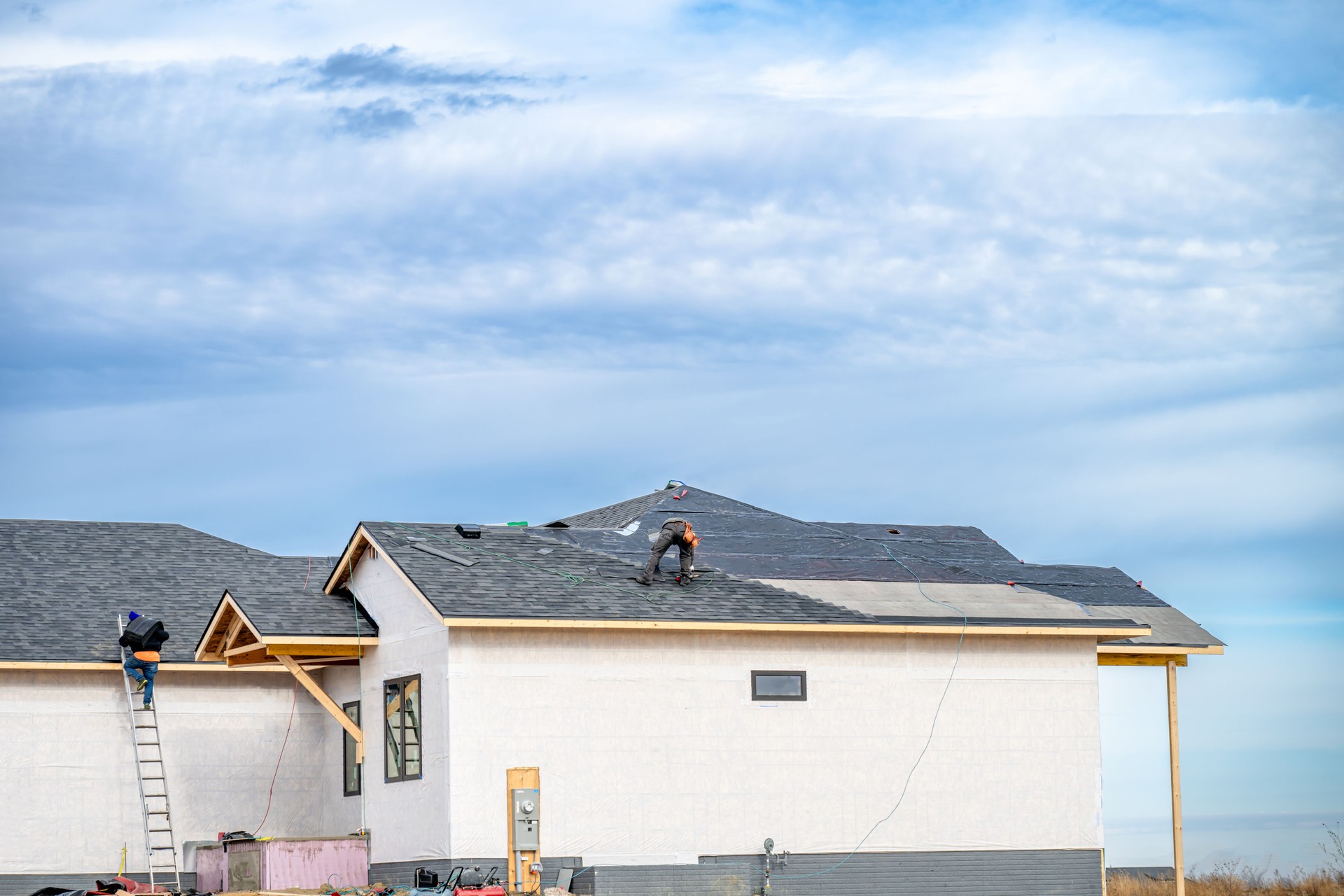 Shingle roof being installed on a two-story walkout new build residential construction house.